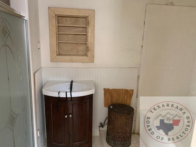 bathroom featuring walk in shower and vanity