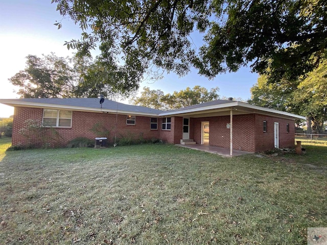 back of house featuring a patio area and a lawn