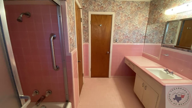 bathroom with vanity, tiled shower / bath, and tile walls