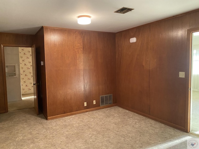 unfurnished room featuring wood walls