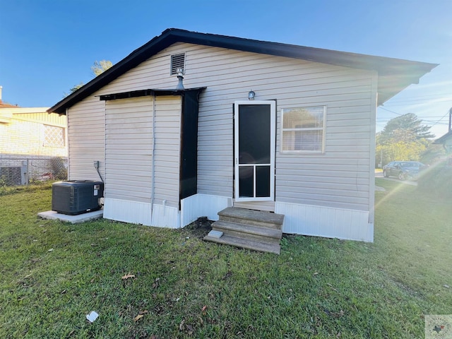 back of house featuring cooling unit and a yard