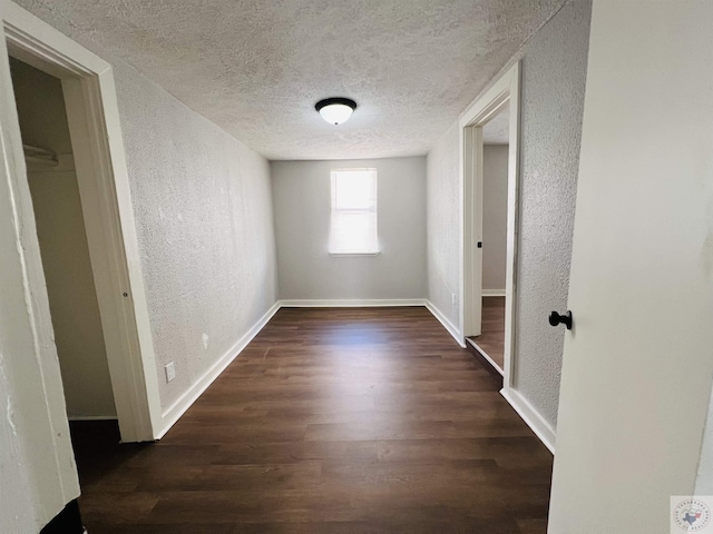 interior space featuring a textured ceiling and dark hardwood / wood-style flooring