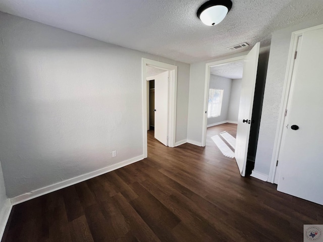 hallway featuring dark hardwood / wood-style floors and a textured ceiling