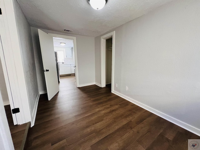 interior space with dark wood-type flooring and a textured ceiling