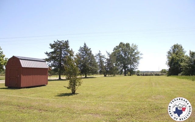 184 E Elliott Ln, Dekalb, TX 75559 - view of green lawn with a storage unit and an outbuilding