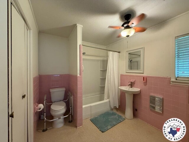 184 E Elliott Ln, Dekalb, TX 75559 - full bathroom with tile walls, toilet, wainscoting, a ceiling fan, and shower / bath combo with shower curtain
