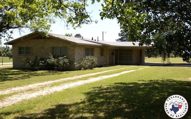 184 E Elliott Ln, Dekalb, TX 75559 - single story home with an attached garage, driveway, and a front lawn