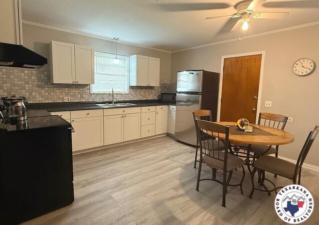 184 E Elliott Ln, Dekalb, TX 75559 - kitchen with freestanding refrigerator, a sink, tasteful backsplash, dark countertops, and ornamental molding