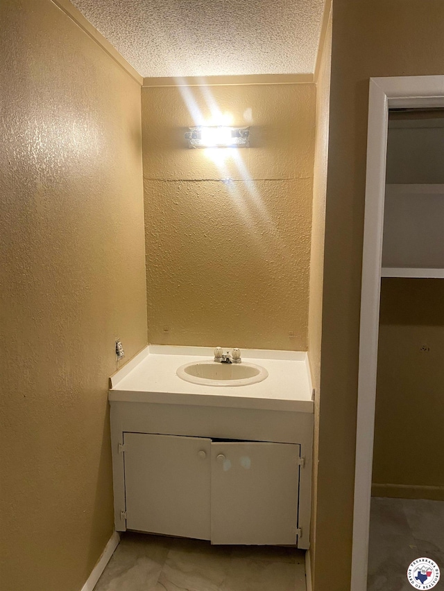 100 Roosevelt St, Hooks, TX 75561 - bathroom featuring baseboards, vanity, a textured wall, and a textured ceiling