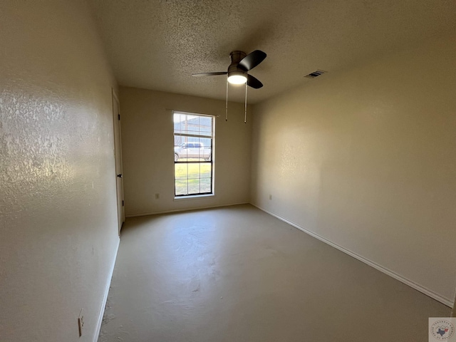 unfurnished room with ceiling fan and a textured ceiling