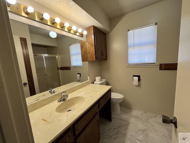 bathroom with vanity, a healthy amount of sunlight, an enclosed shower, and a textured ceiling