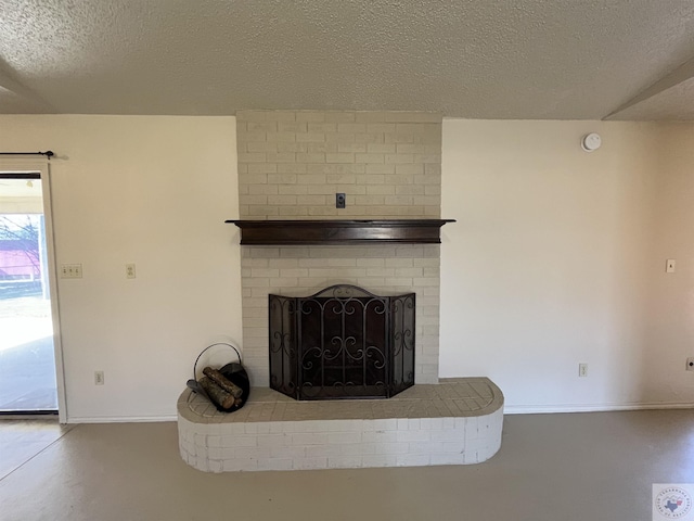 interior details with a fireplace, concrete floors, and a textured ceiling