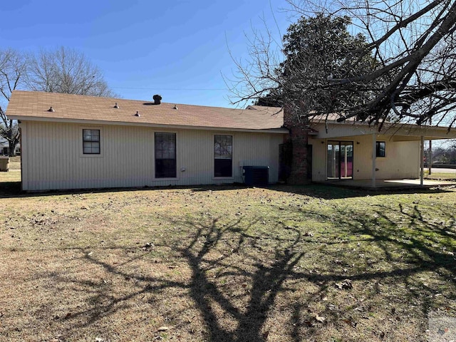 rear view of house with a patio, a lawn, and central air condition unit