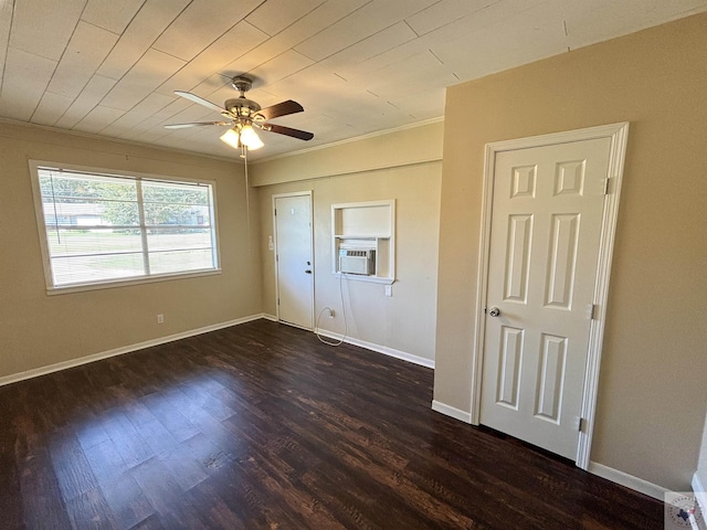 empty room featuring ceiling fan, dark wood-type flooring, cooling unit, and ornamental molding