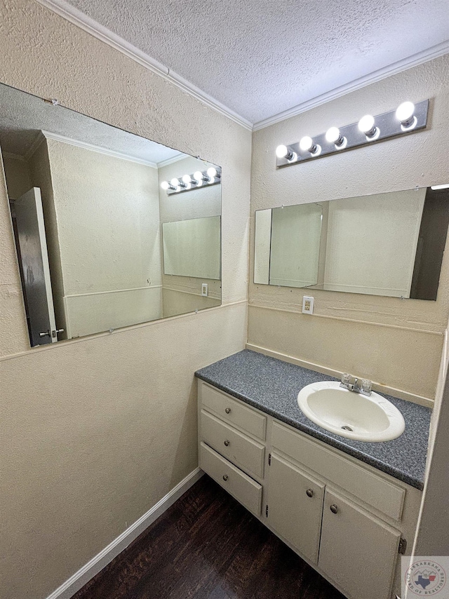 bathroom featuring crown molding, hardwood / wood-style floors, a textured ceiling, and vanity