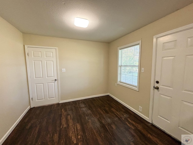 interior space with dark wood-type flooring and a textured ceiling