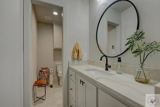 bathroom featuring toilet, tile patterned flooring, and vanity