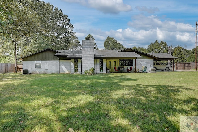 rear view of property with a lawn and central AC