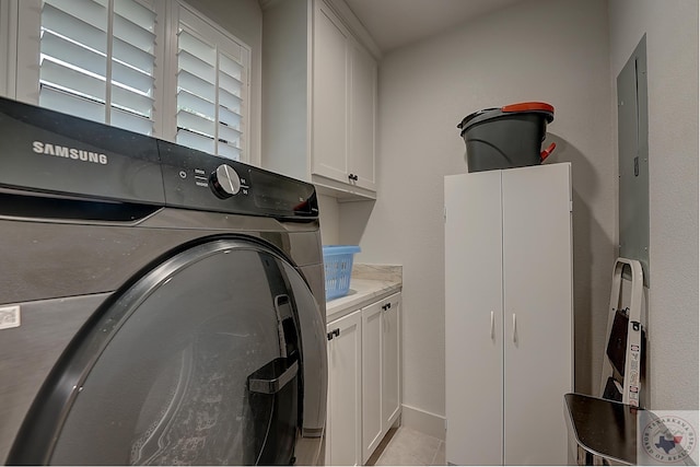 laundry room featuring light tile patterned floors, washer / clothes dryer, and cabinets