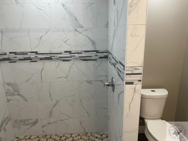 bathroom with toilet and tiled shower