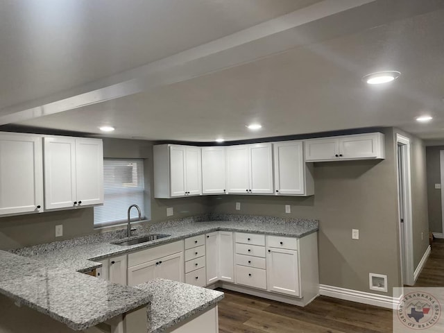 kitchen featuring white cabinets, light stone counters, dark hardwood / wood-style floors, and sink