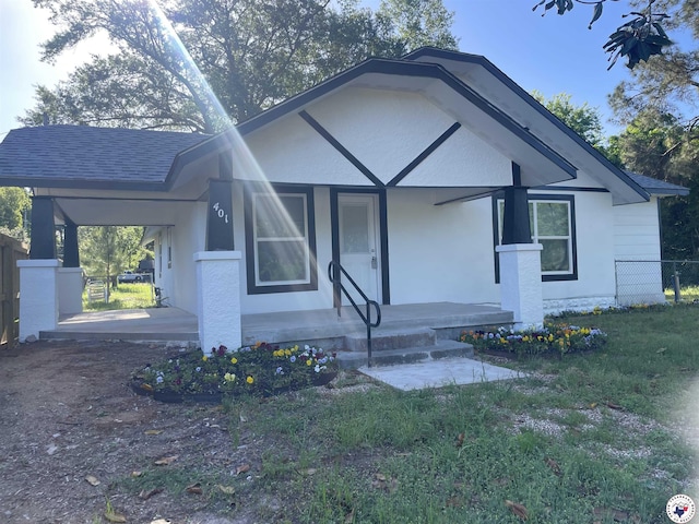 401 S State Line Ave, Texarkana, AR 71854 - view of front of house featuring a porch, a shingled roof, fence, and stucco siding