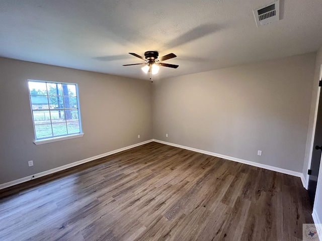 empty room with dark wood-type flooring, a textured ceiling, and ceiling fan