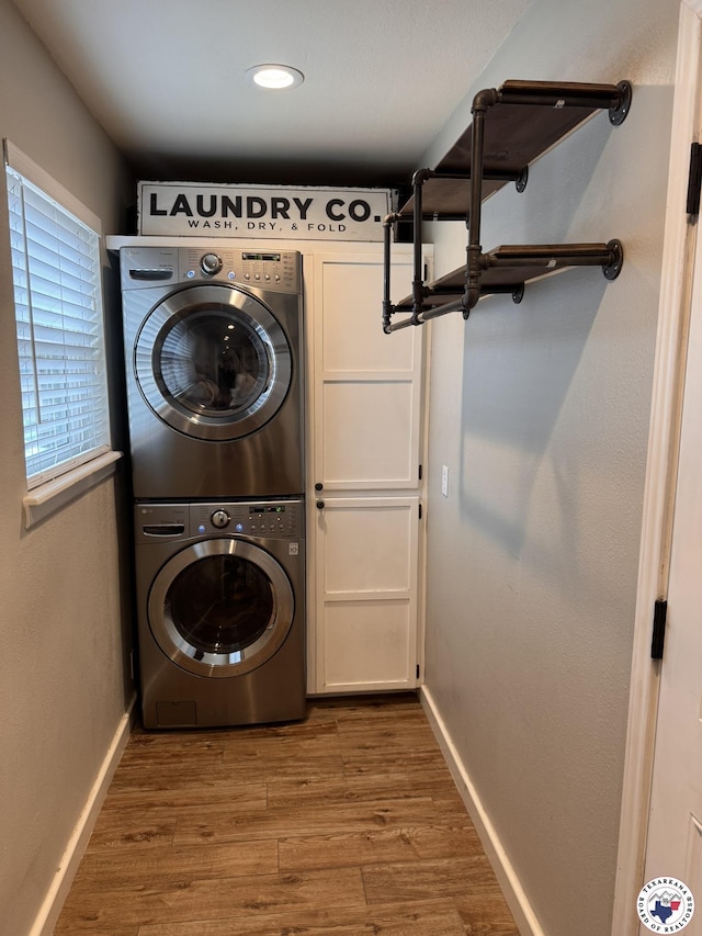 6515 N Kings Hwy, Texarkana, TX 75503 - washroom with stacked washing machine and dryer, wood finished floors, and baseboards