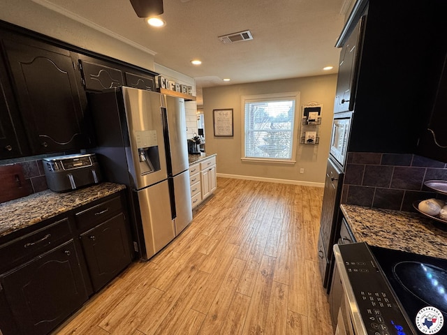 6515 N Kings Hwy, Texarkana, TX 75503 - kitchen with stainless steel appliances, light wood-style flooring, baseboards, dark stone countertops, and recessed lighting