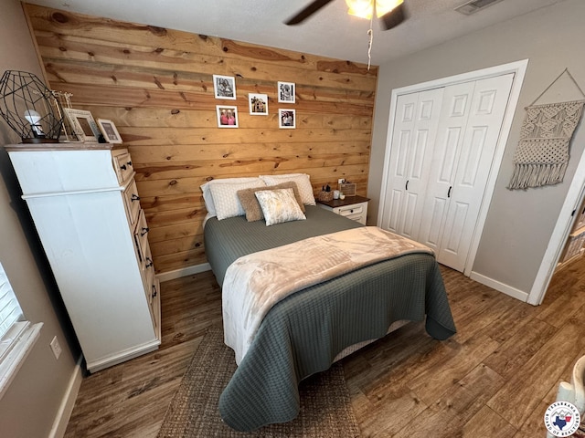 6515 N Kings Hwy, Texarkana, TX 75503 - bedroom with baseboards, wood finished floors, a closet, and wooden walls