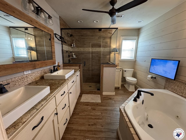 6515 N Kings Hwy, Texarkana, TX 75503 - bathroom with wood finished floors, a shower stall, a ceiling fan, a whirlpool tub, and toilet