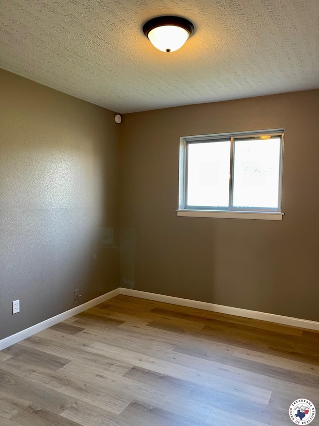 1 Sidney Dr, Texarkana, TX 75503 - spare room featuring wood finished floors, baseboards, and a textured ceiling