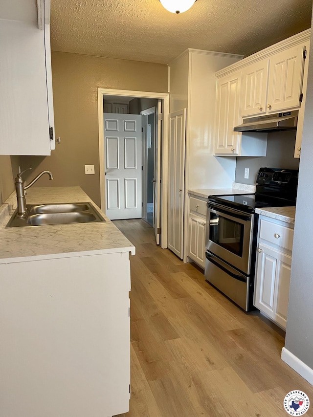 1 Sidney Dr, Texarkana, TX 75503 - kitchen featuring stainless steel range with electric cooktop, under cabinet range hood, a sink, light wood-type flooring, and a textured ceiling