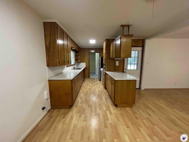 3123 Hickory St, Texarkana, AR 71854 - kitchen featuring light wood finished floors, light countertops, brown cabinets, crown molding, and freestanding refrigerator