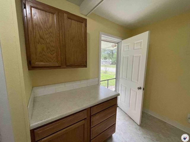 3123 Hickory St, Texarkana, AR 71854 - kitchen featuring brown cabinetry, light countertops, and beamed ceiling