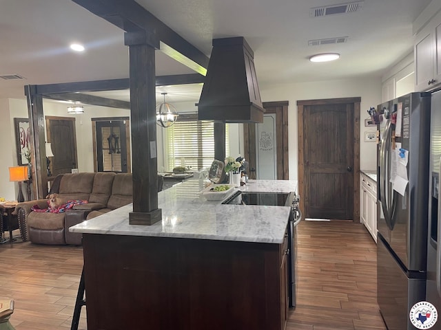24075 US Highway 59 N, Queen City, TX 75551 - kitchen with appliances with stainless steel finishes, dark wood finished floors, light stone countertops, open floor plan, and a chandelier
