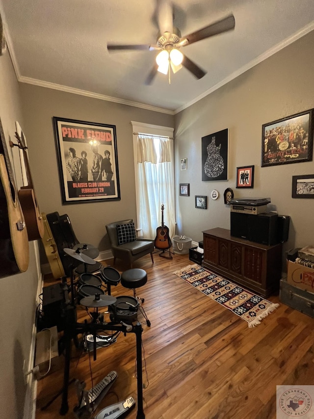 interior space featuring crown molding, wood-type flooring, and ceiling fan