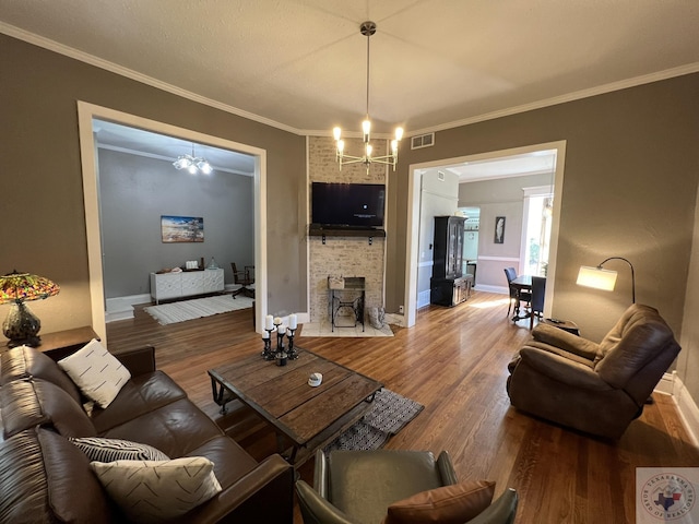 living room with a notable chandelier, hardwood / wood-style floors, and crown molding