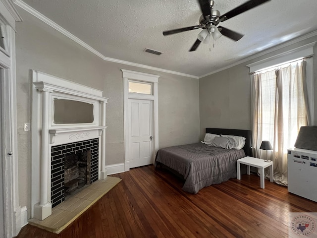 bedroom featuring ceiling fan, a textured ceiling, dark wood-type flooring, and a fireplace