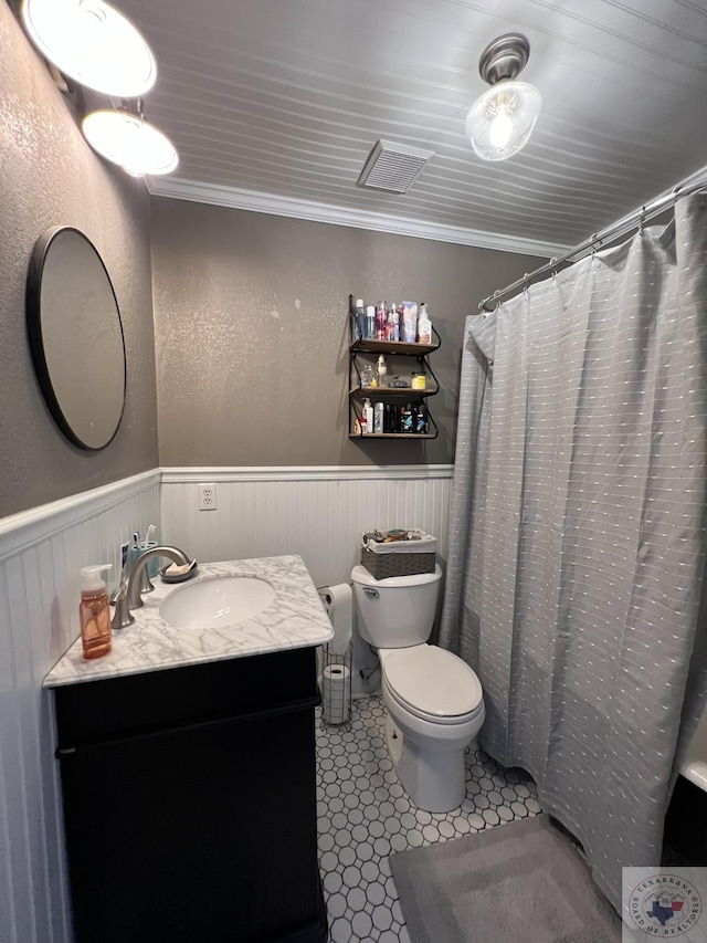 bathroom featuring vanity, toilet, ornamental molding, and tile patterned floors