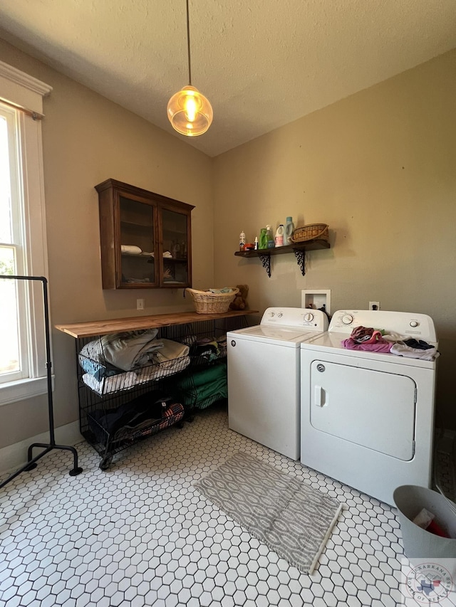 laundry room with a textured ceiling and washer and clothes dryer