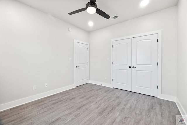 unfurnished bedroom featuring light wood finished floors, baseboards, visible vents, and a closet