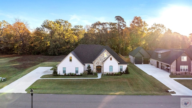 view of front of home with a front yard, stone siding, and driveway