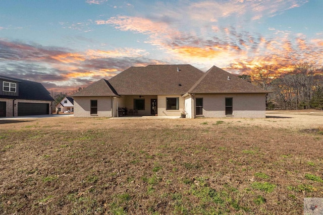 ranch-style house featuring a front lawn, a patio, and brick siding