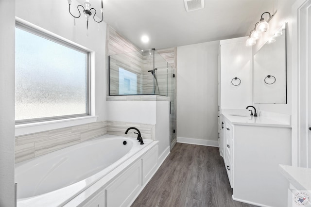 bathroom featuring visible vents, vanity, a shower stall, wood finished floors, and a bath