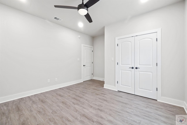 unfurnished bedroom featuring light wood finished floors, baseboards, visible vents, a ceiling fan, and a closet