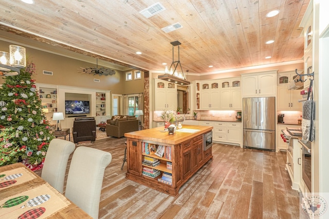 kitchen with pendant lighting, white cabinets, stainless steel appliances, sink, and wooden ceiling