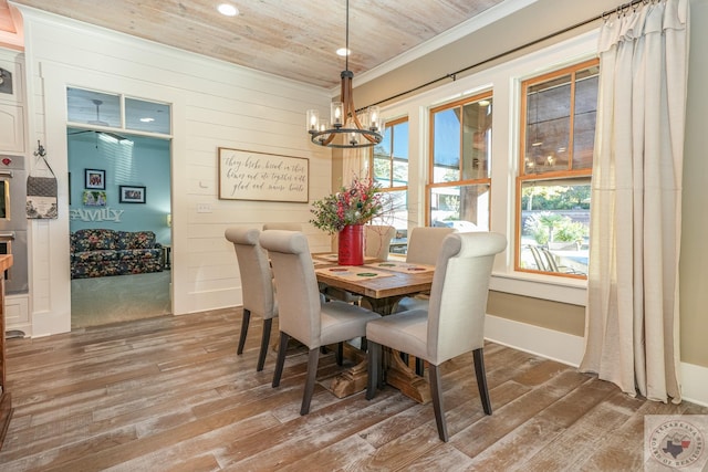 dining area with wood walls, wooden ceiling, hardwood / wood-style floors, and a notable chandelier