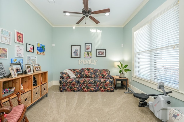 living area with ornamental molding, carpet flooring, and ceiling fan