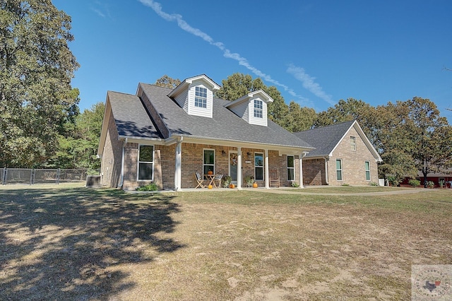 new england style home with a porch and a front lawn